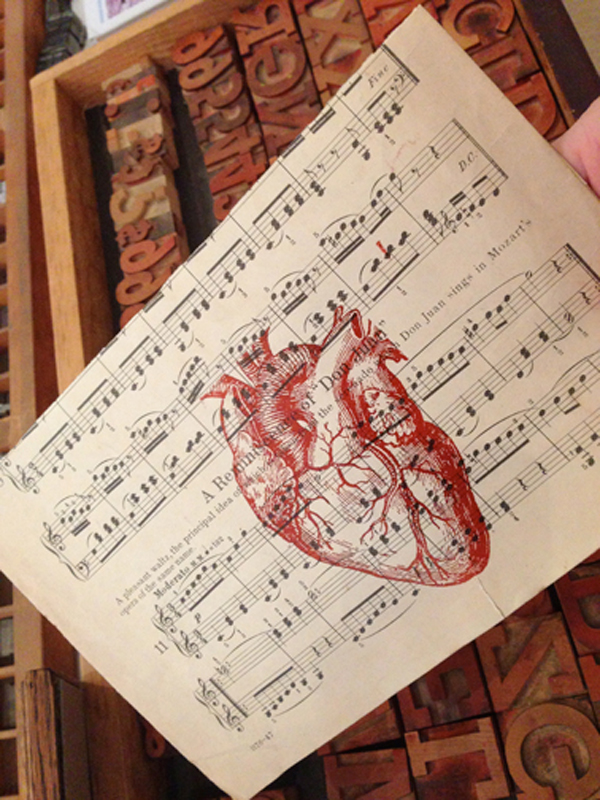 Letterpressed anatomical heart over music sheet printed by Appalachia Press.